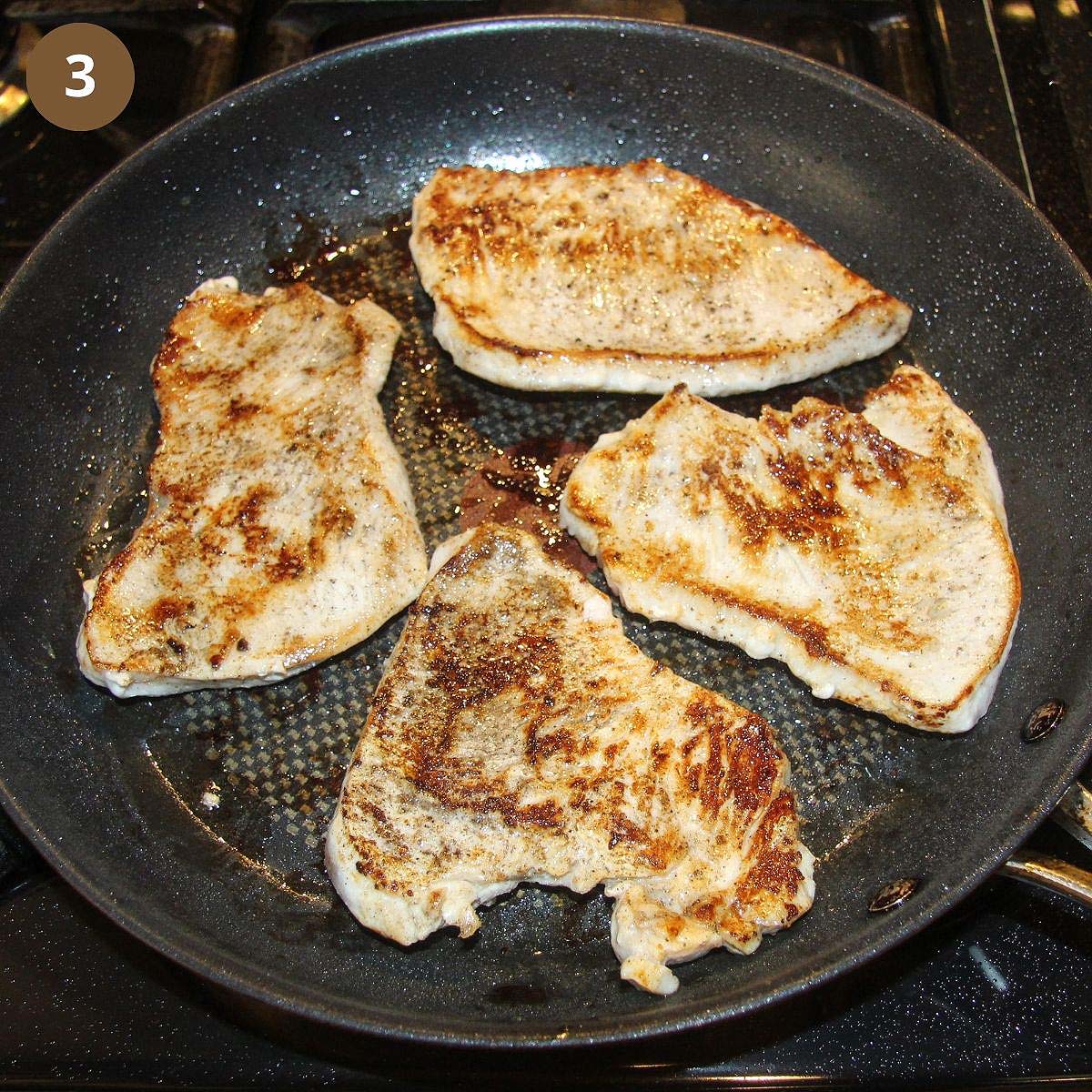 four turkey cutlets fried in a nonstick pan.