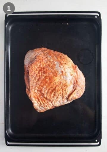 seasoned turkey thigh joint on a baking sheet.