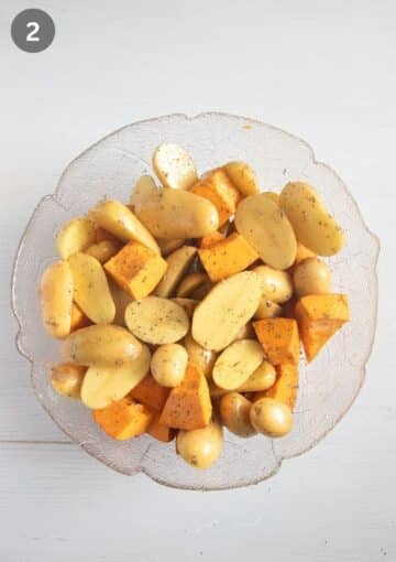 seasoned potato halves and pumpkin pieces in a large bowl.