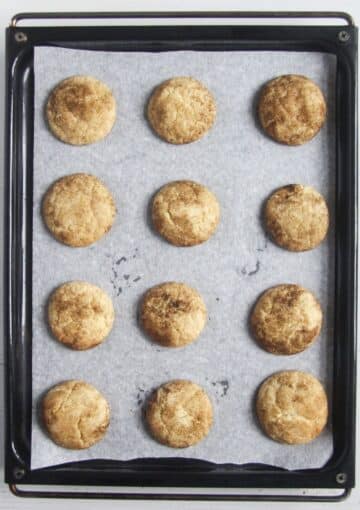 12 baked snickerdoodles without cream of tartar on a baking sheet.