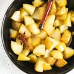 pin image of pear with spices cooked in syrup.
