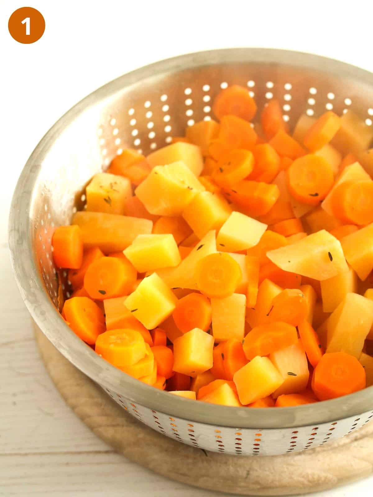 draining rutabaga and carrots in a colander.
