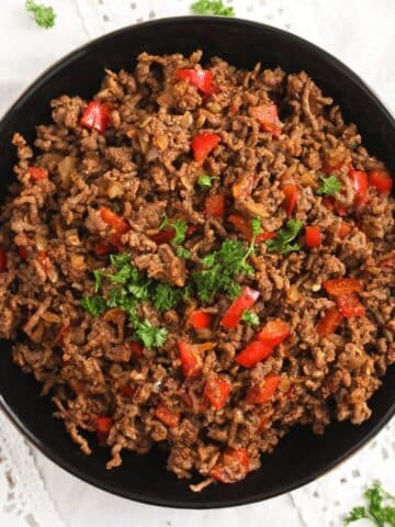 bowl with cooked beef from frozen with pepper pieces in it.