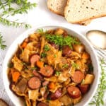 pinterest image of cabbage and sausage in a bowl.