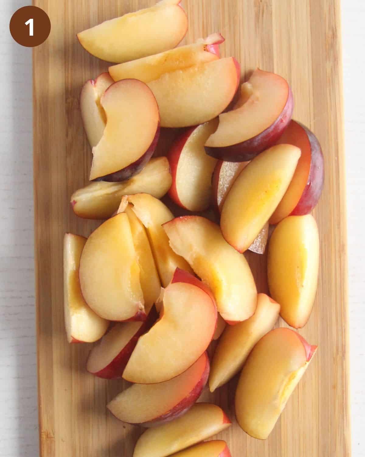 sliced plums on a wooden board.
