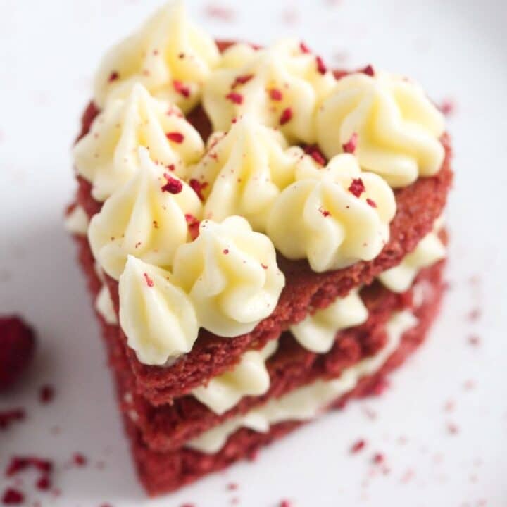 close up red velvet mini cake with piped cream cheese frosting on top.