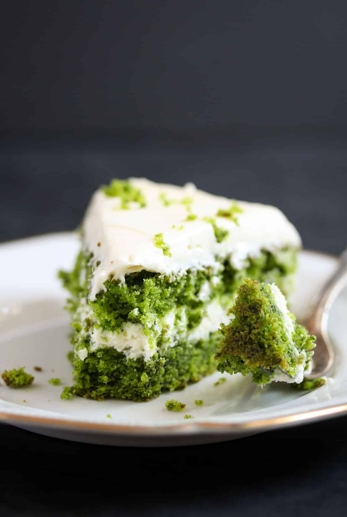 taking a piece of a green cake with a fork.