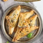 pinterest image with title of feta spinach triangles.