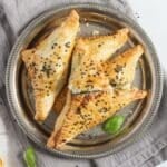 feta and spinach triangles close up on a plate.