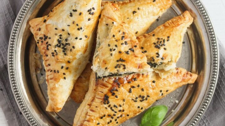 feta and spinach triangles close up on a plate.