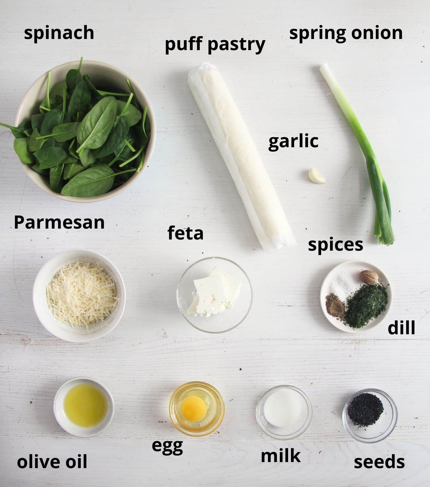 listed ingredients for making cheese and spinach triangles on the table.
