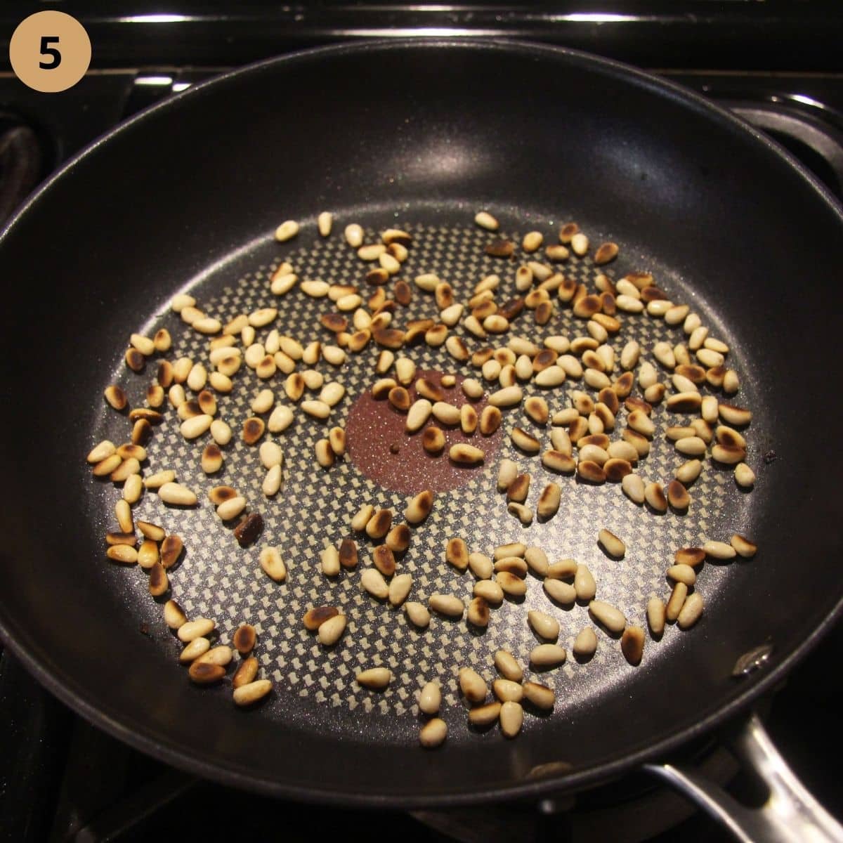roasting pine nuts in a pan.