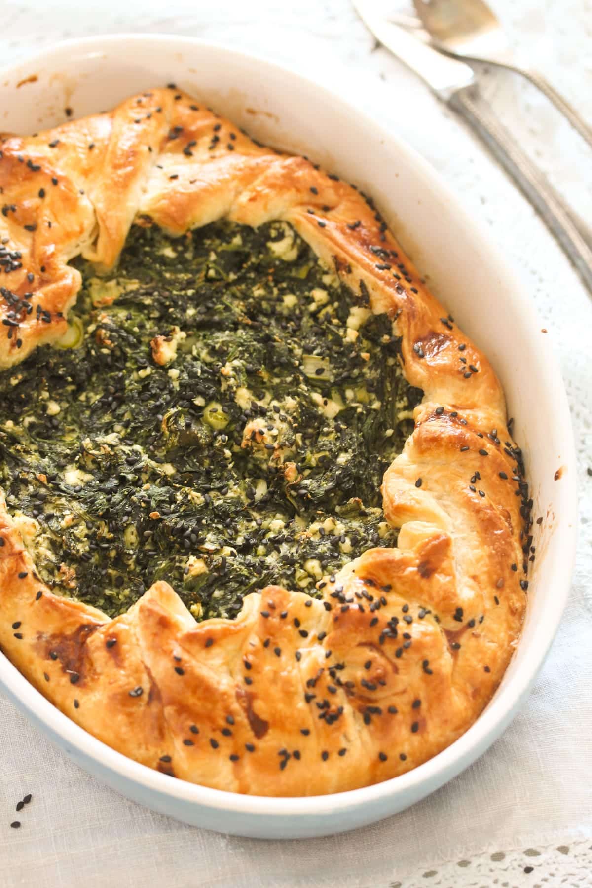 golden brown puff pastry spanakopita sprinkled with black sesame seeds.
