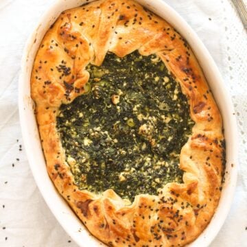 overhead view of greek spinach pie with feta in a baking dish.