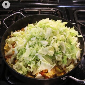 adding fresh cabbage to a pot to make stew.