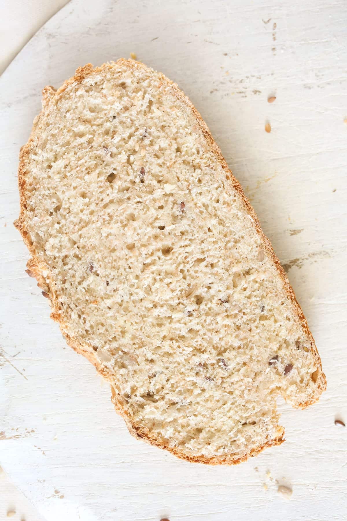 slice of bread with seeds on a white board.