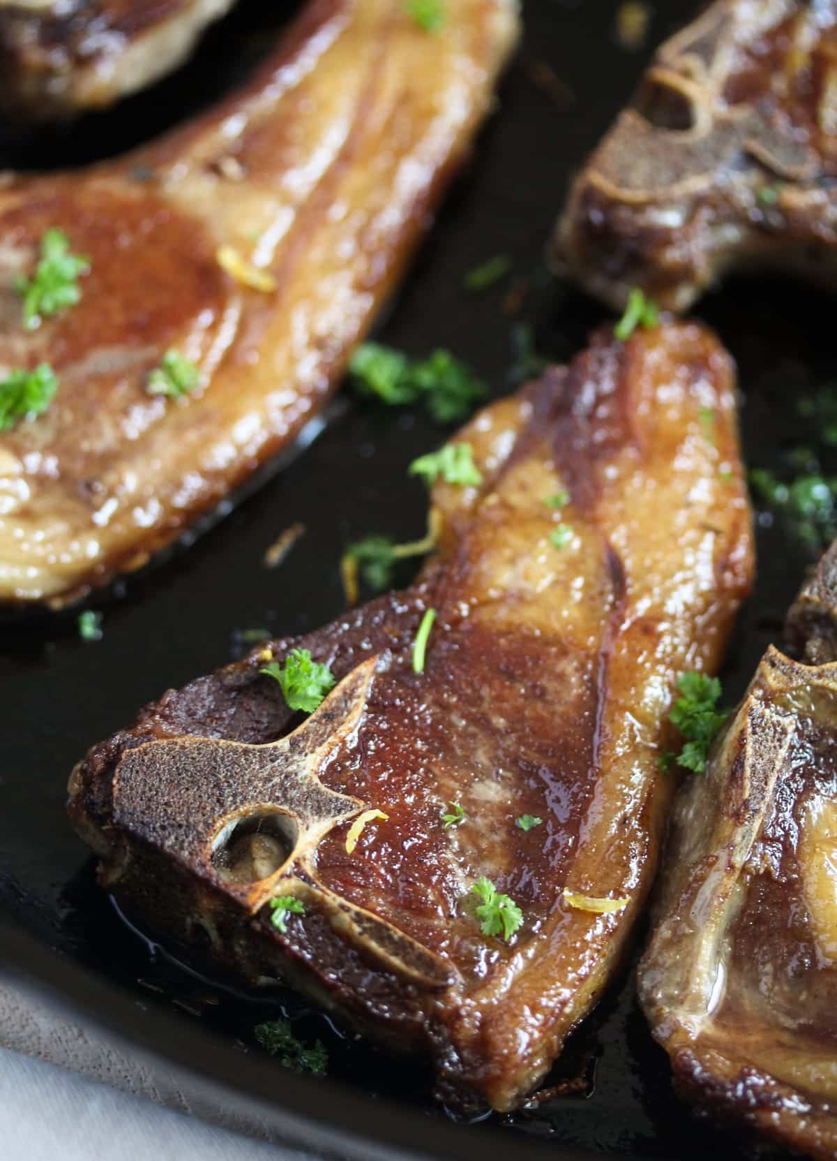 close up of lamb chops sprinkled with parsley.
