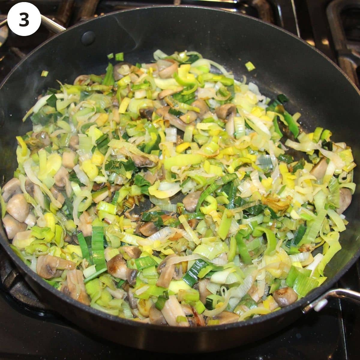 cooking leeks and mushrooms in a pan.