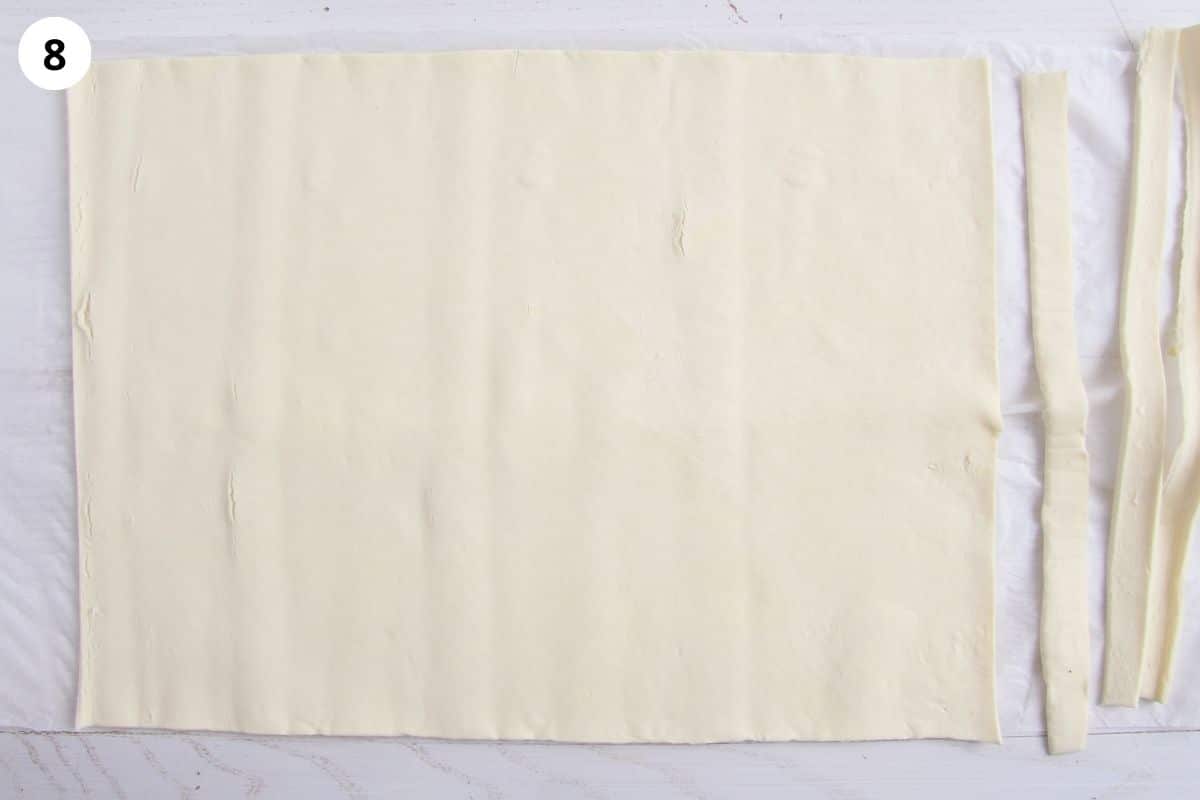 cutting strips off a sheet of puff pastry.