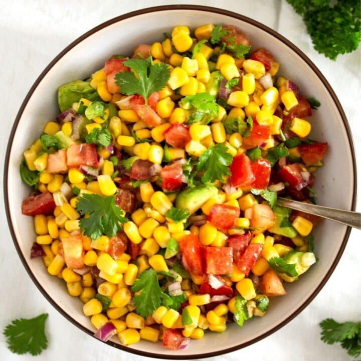 fiesta corn salad with avocado and tomatoes in a bowl.