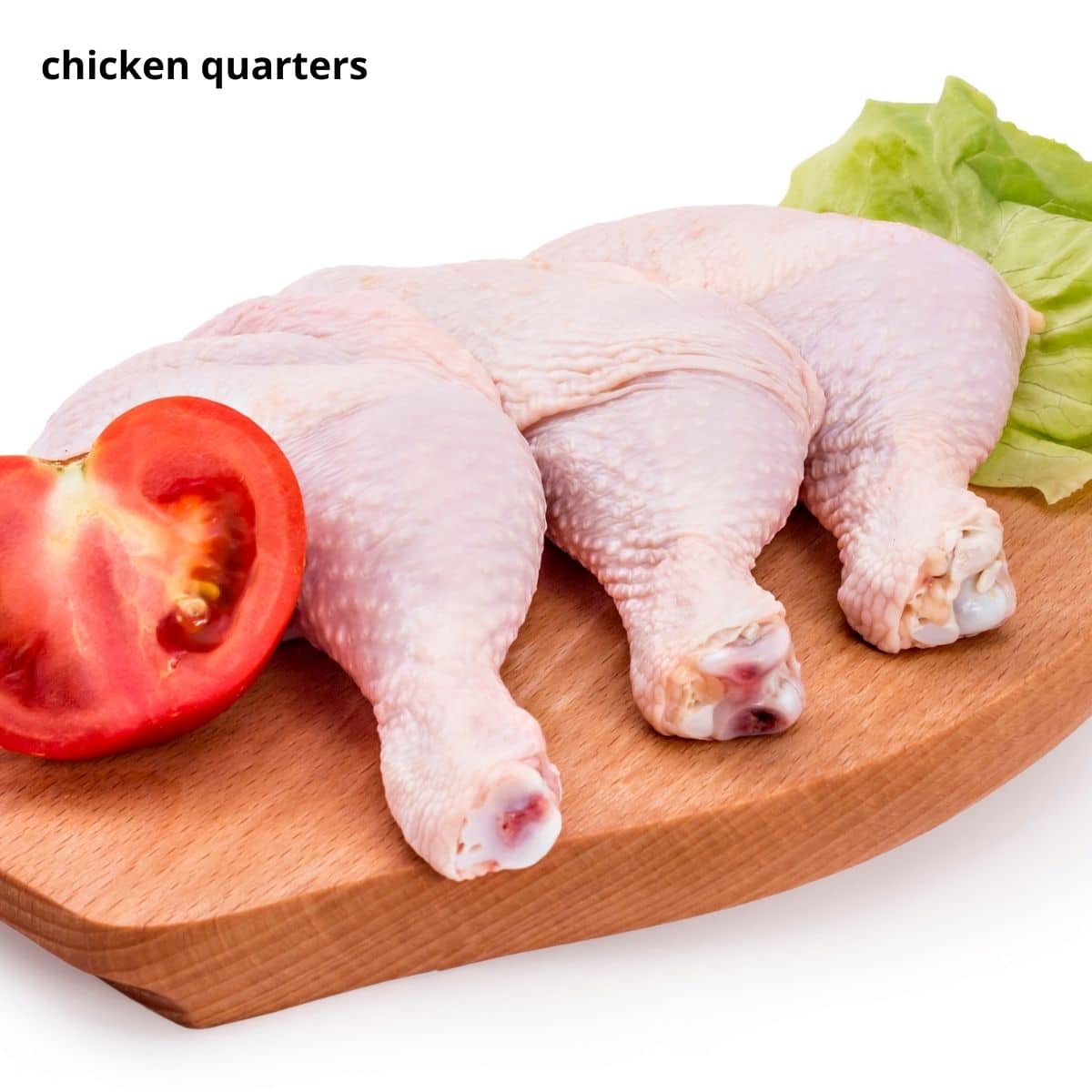 three raw chicken quarters and half a tomato on a wooden board.