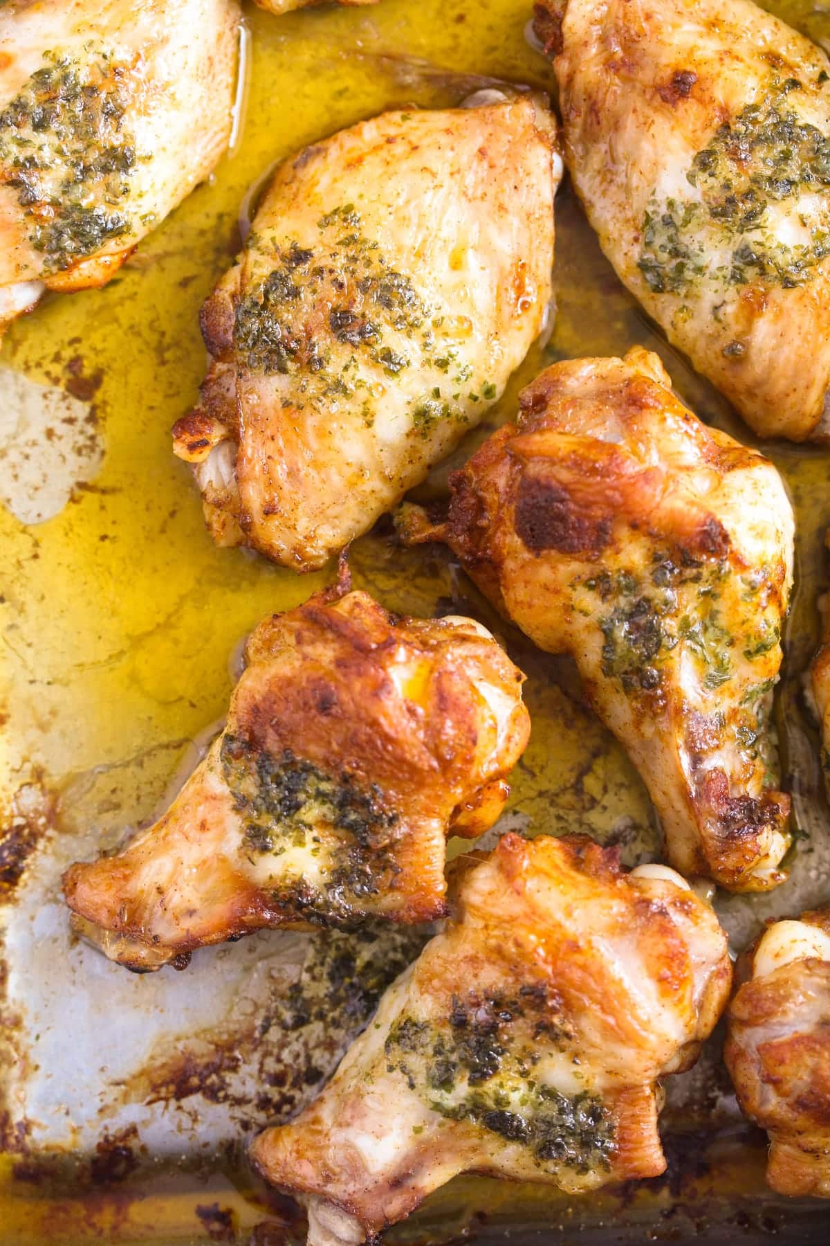 juicy golden chicken wings with butter sauce in a baking tin.