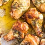 close up of several golden buttered chicken wings with melted butter around.