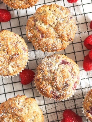 white chocolate and raspberries muffins close up on a rack.