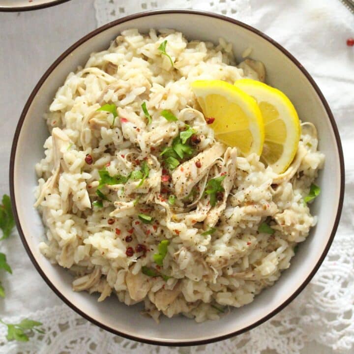bowl of southern boiled rice and chicken served with parsley and lemon.