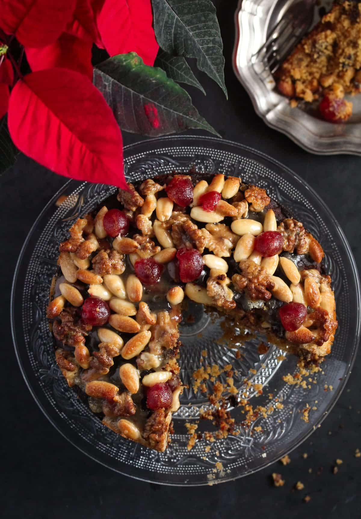 overhead view of mincemeat fruitcake with a slice mixing and a red christmas flower above it.