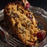 pinterest image with title of a slice of fruitcake on dark background.