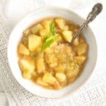 stewed rhubarb and apples in a bowl with a spoon in it.