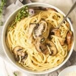 truffle oil pasta with mushrooms in a bowl with a fork in it.