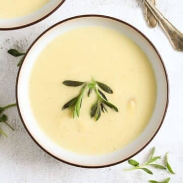 overhead view of a bowl with velvety white asparagus soup.