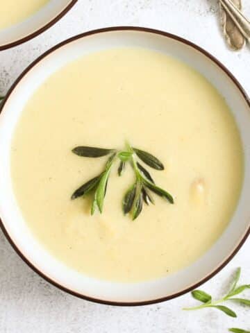 overhead view of a bowl with velvety white asparagus soup.