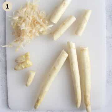 peeling and removing the woody ends from white asparagus.