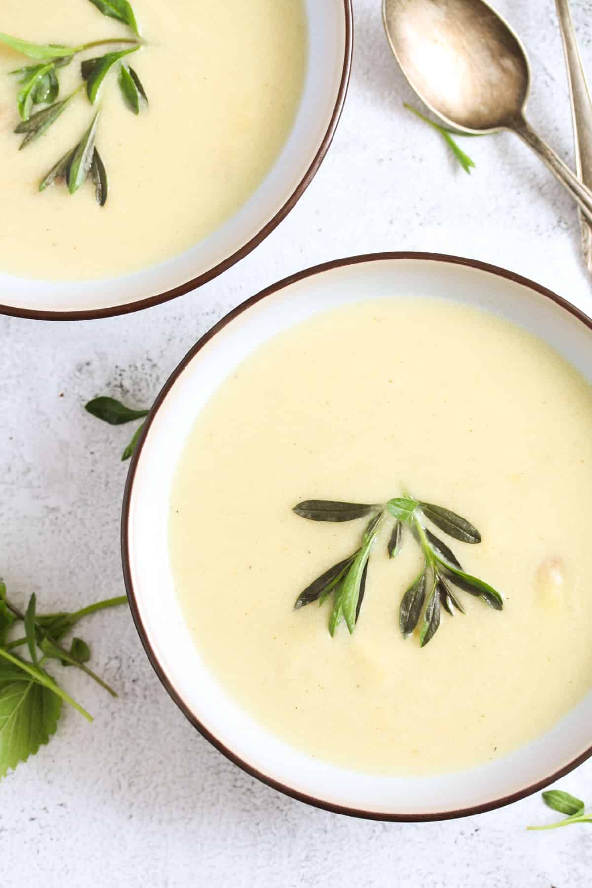 two bowls of soup with asparagus, cream and tyhme.