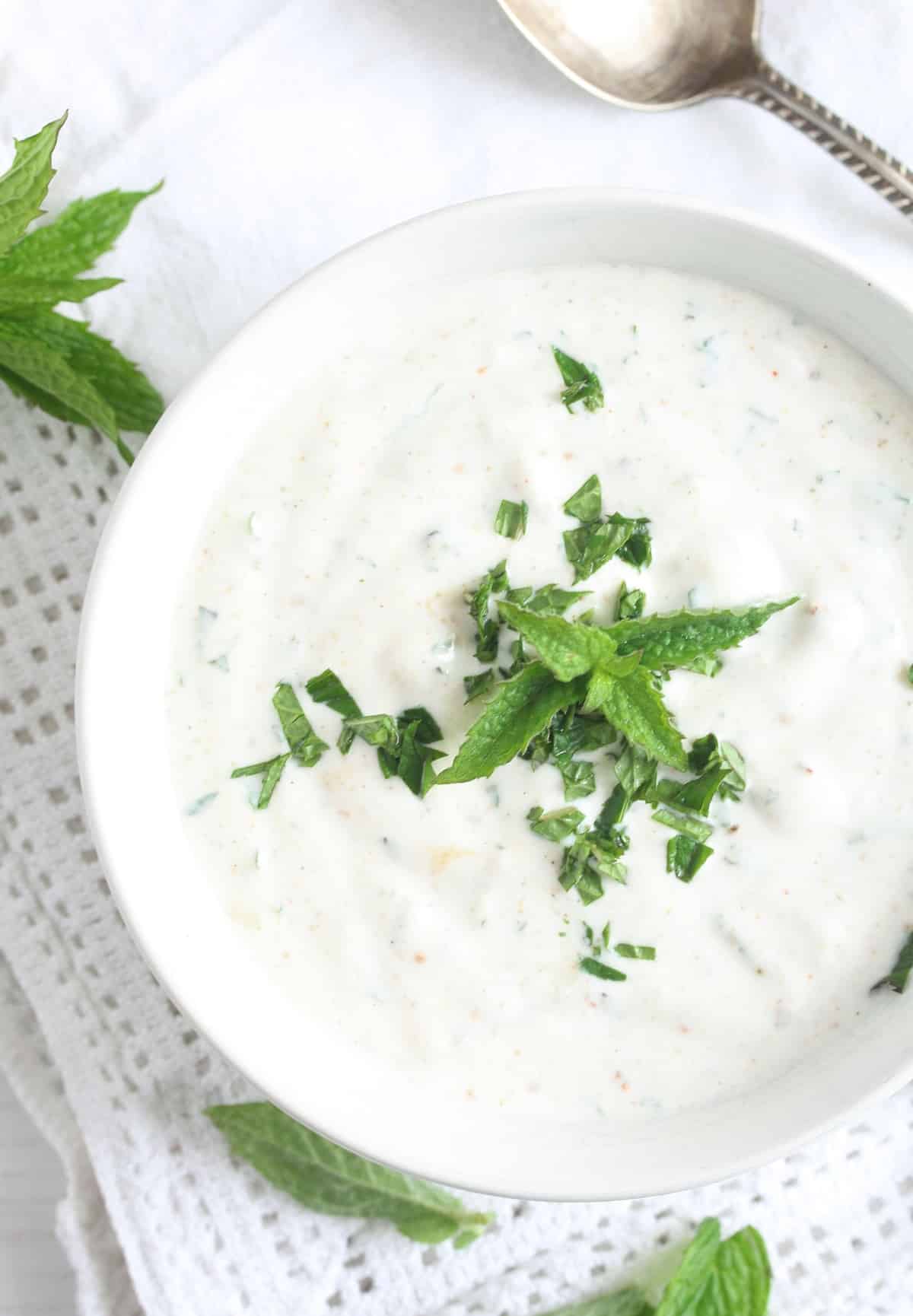 bowl with greek yogurt sauce with mint for lamb and vegetables.