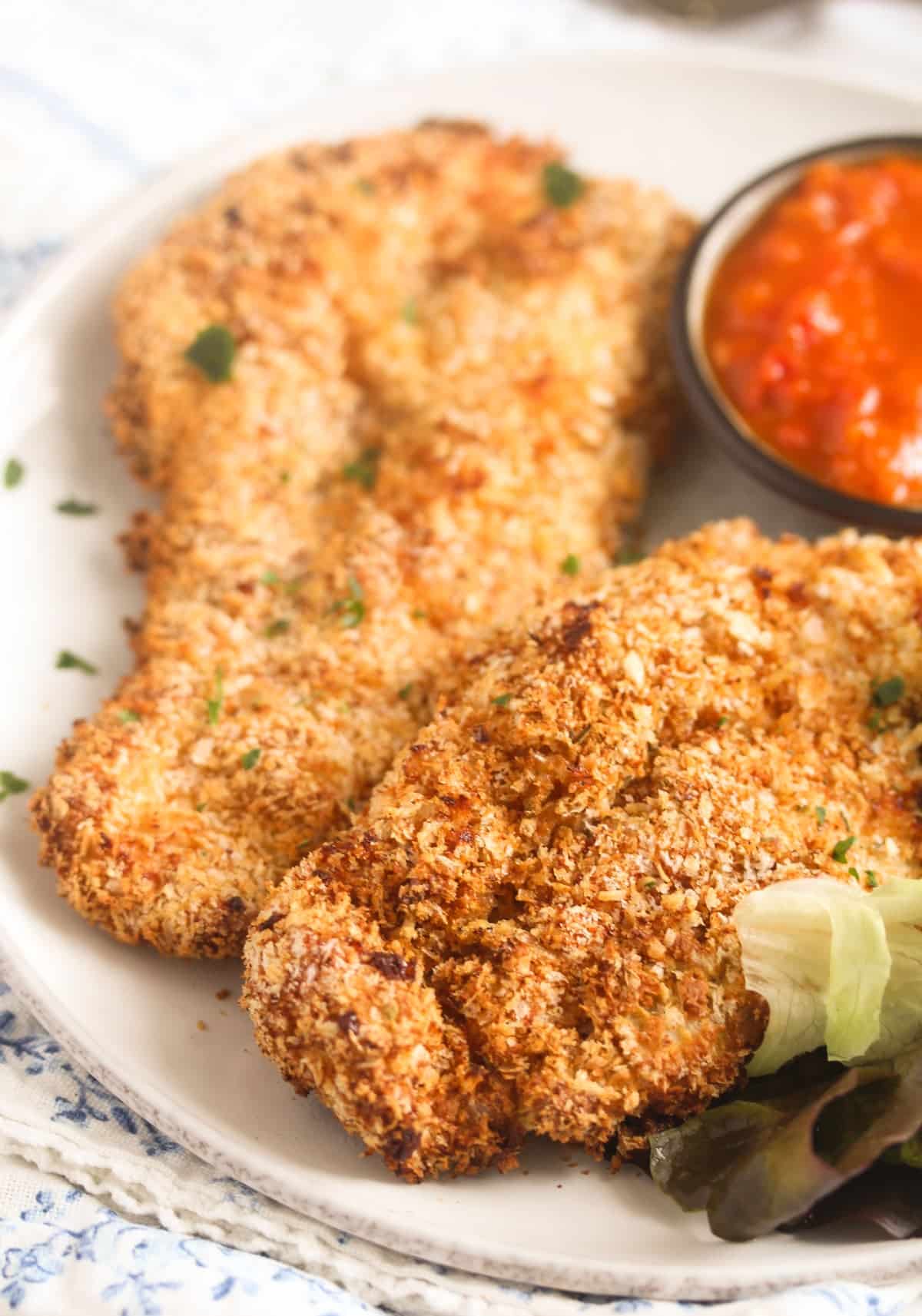 two slices of air fried chicken with panko crust close up.