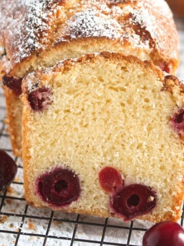 close up of a slice of cherry bread on a rack.