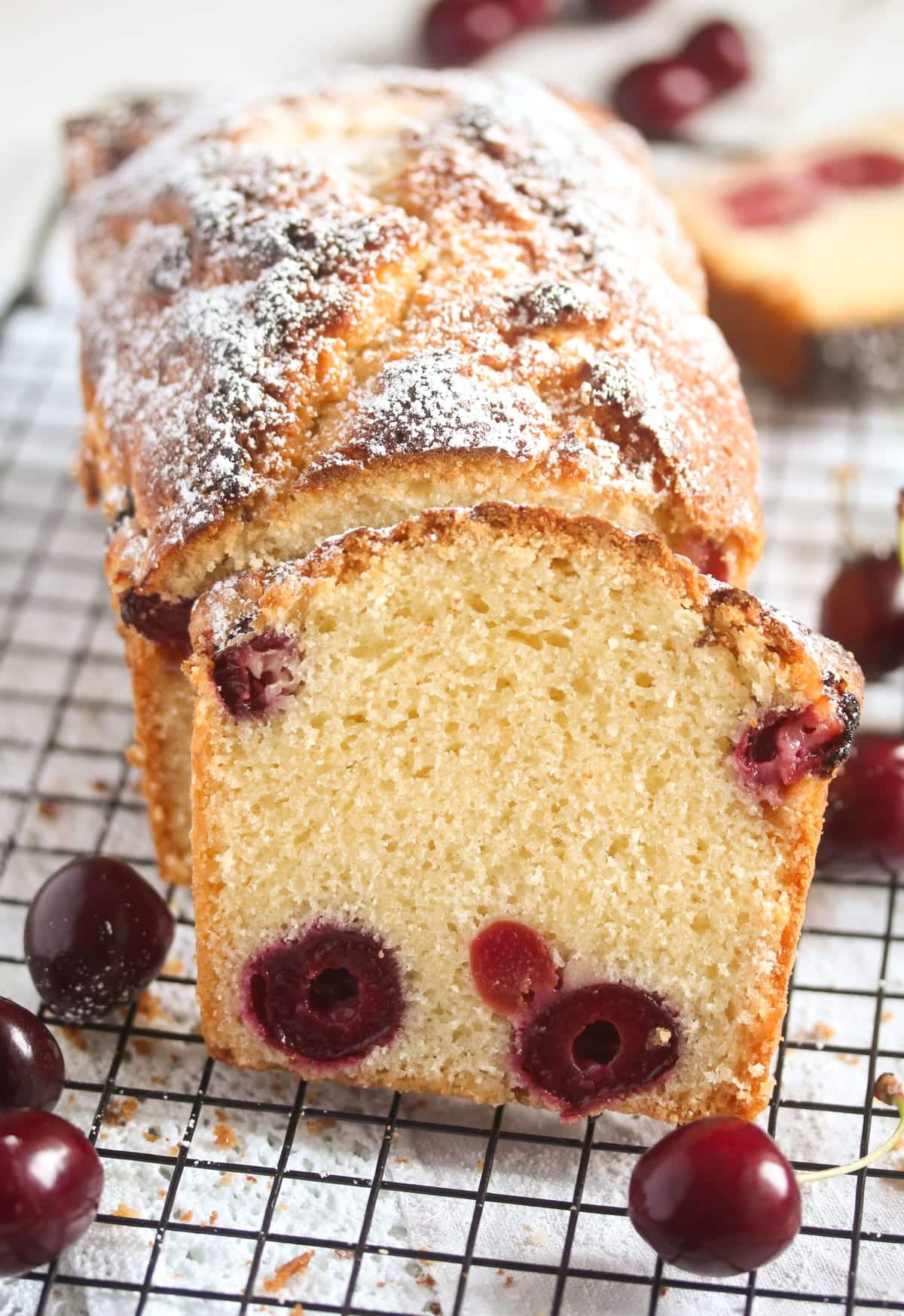 sliced loaf of bread studded with cherries and sprinkle with icing sugar.