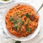 overhead view of a plate full of chimichurri rice sprinkled with herbs.