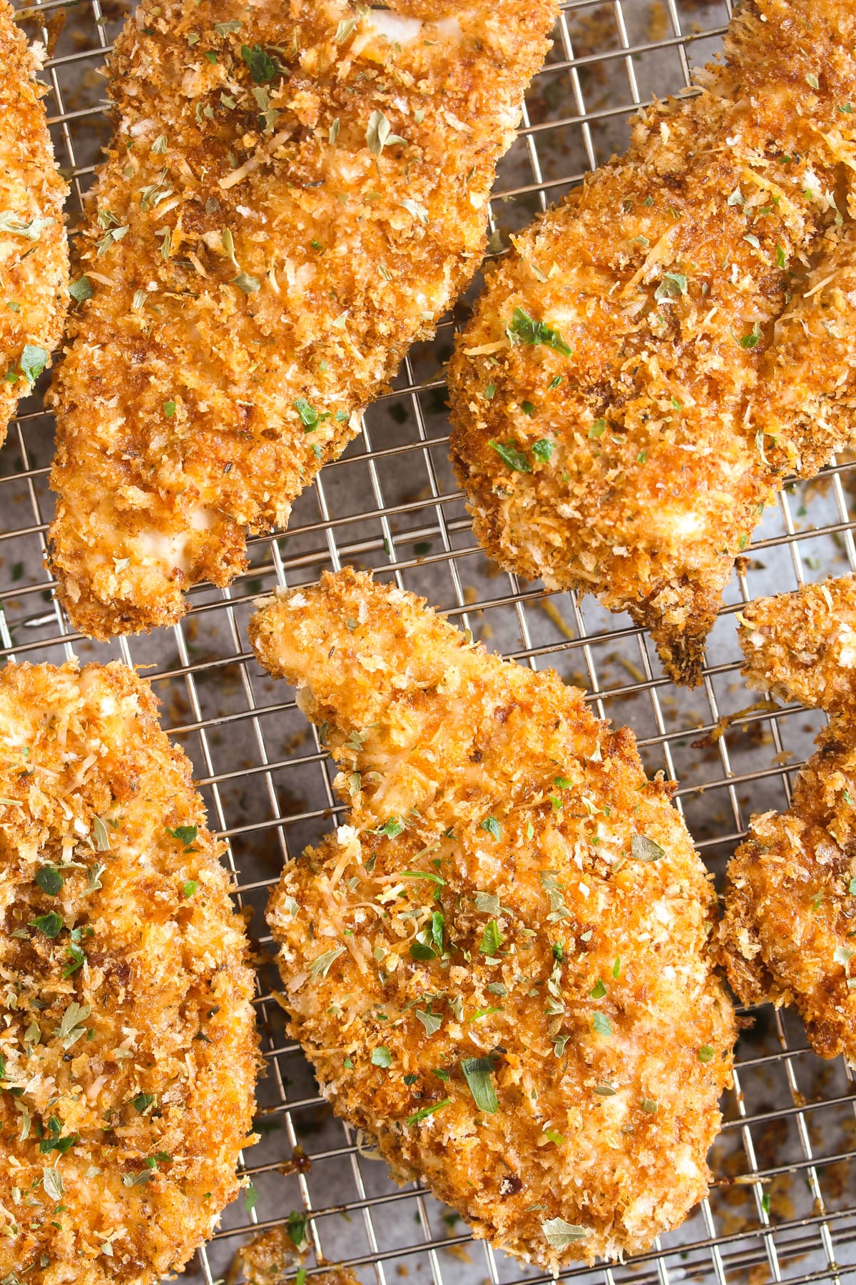 many golden panko chicken pieces on a wire rack.