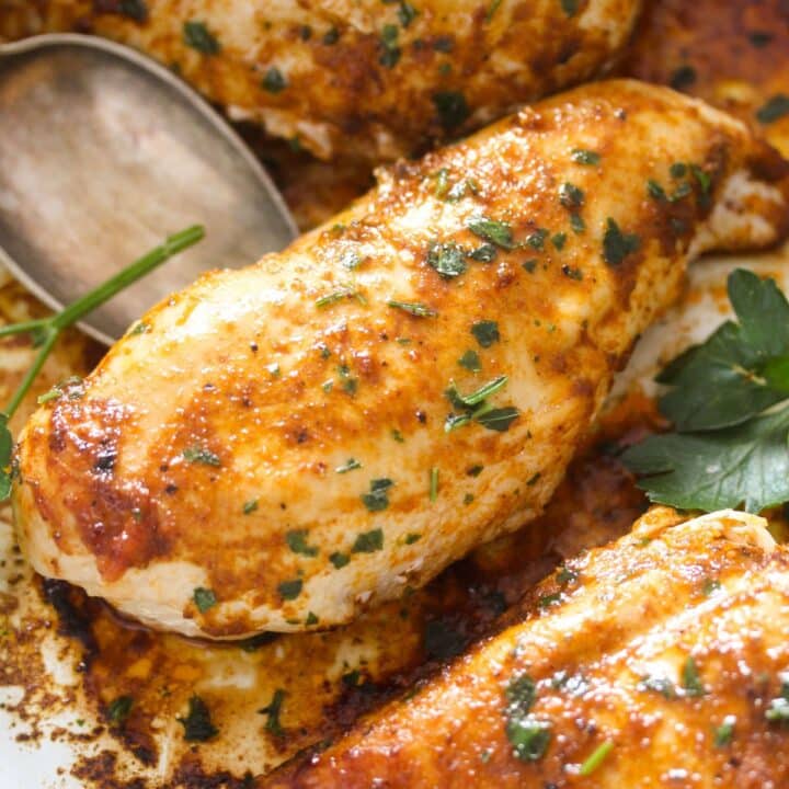 lifting one piece of baked chicken breast with a spoon.