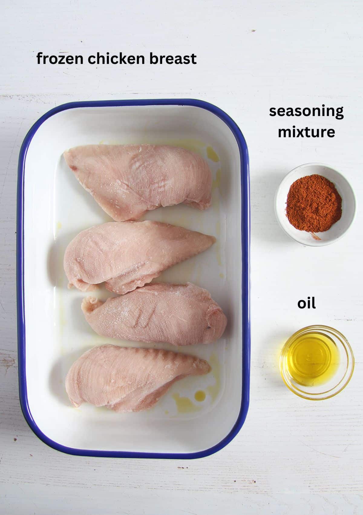 labeled ingredients for baking frozen chicken breast with seasoning and olive oil.