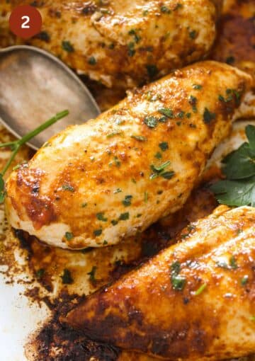 one spoon lifting one pieces of golden baked chicken breast.