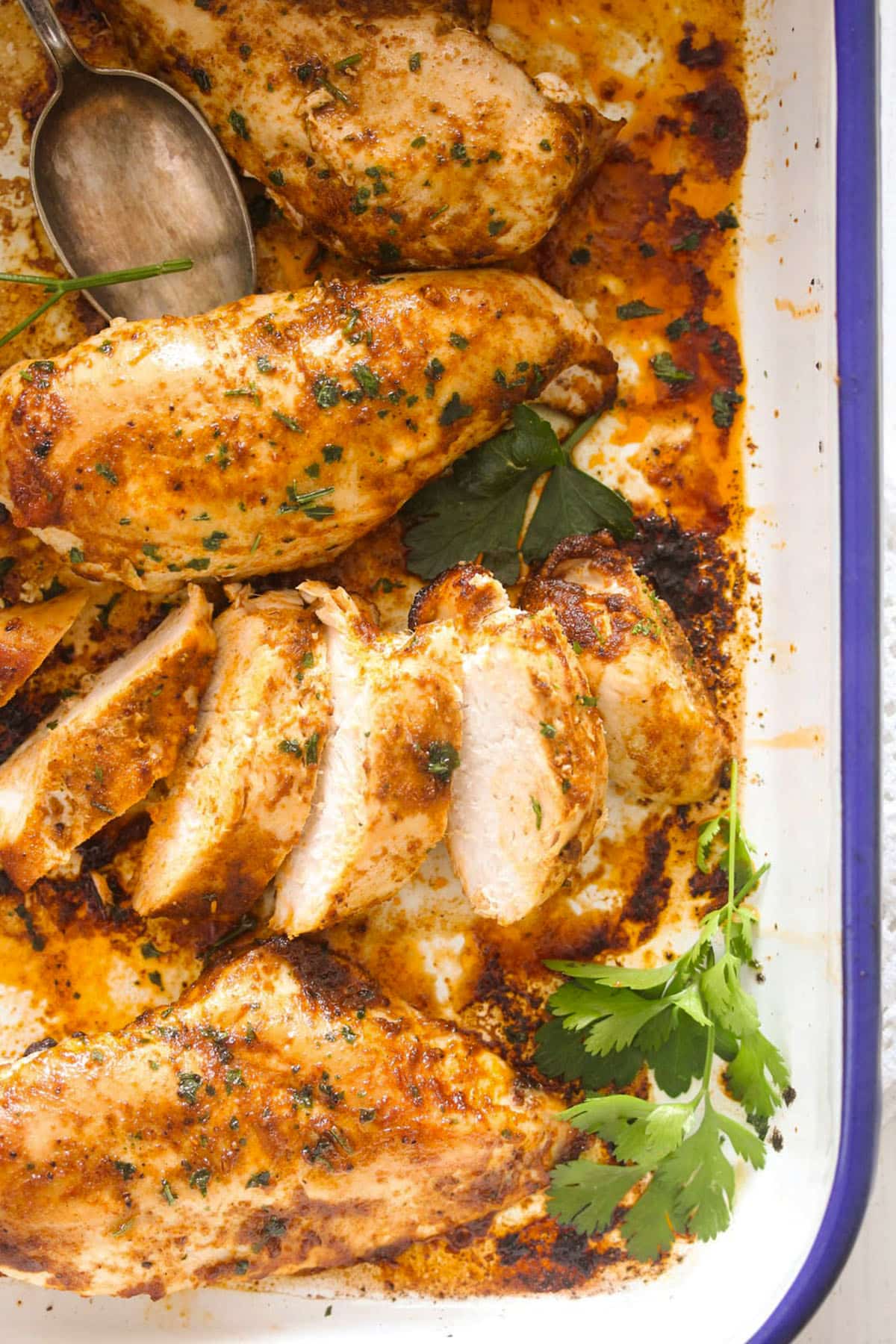 four chicken breasts baked from frozen, one of them sliced.