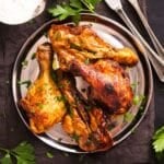 overhead view of butterflied chicken legs on a silver plate.