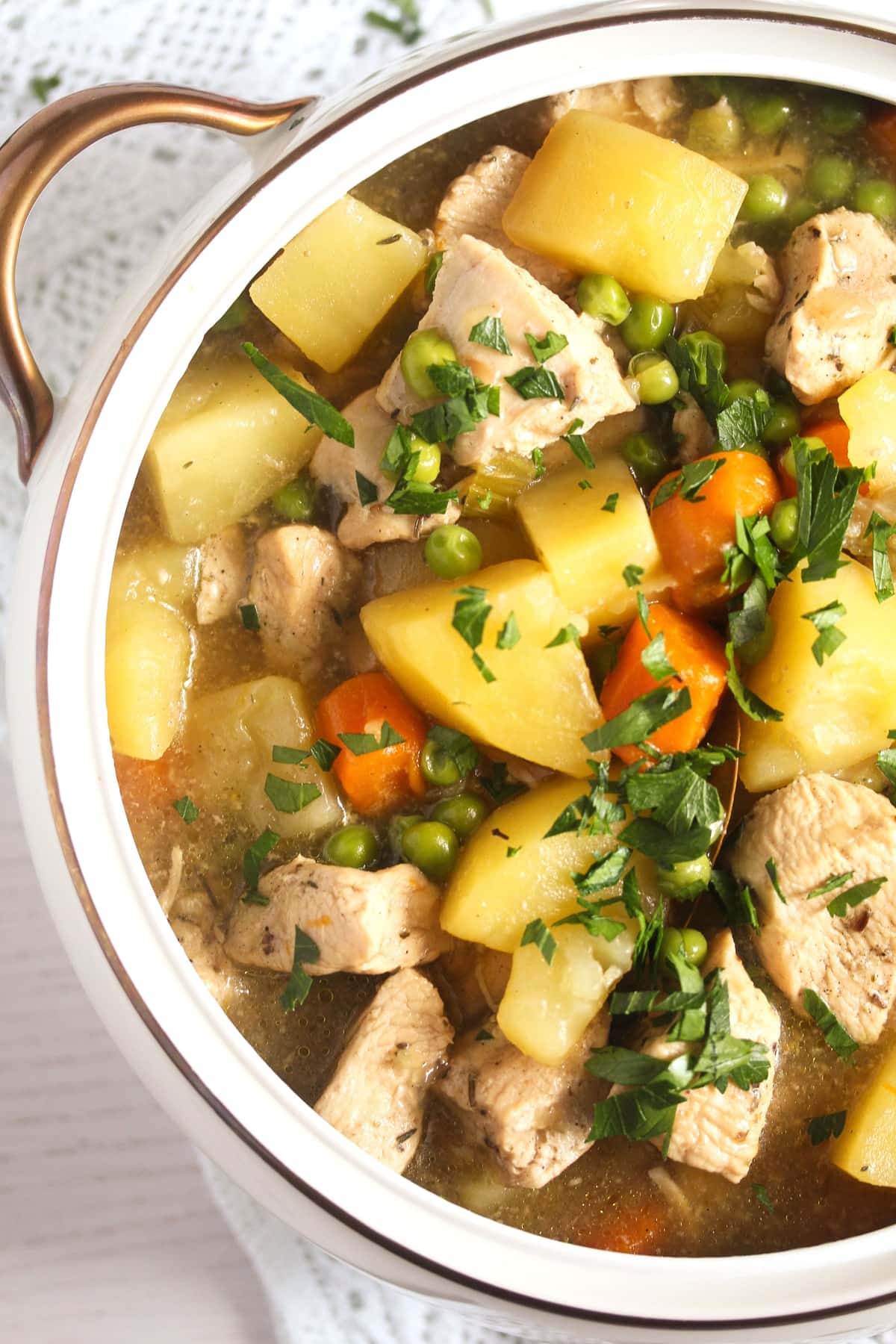 close up of a large bowl full of stew with chicken breast and carrots.