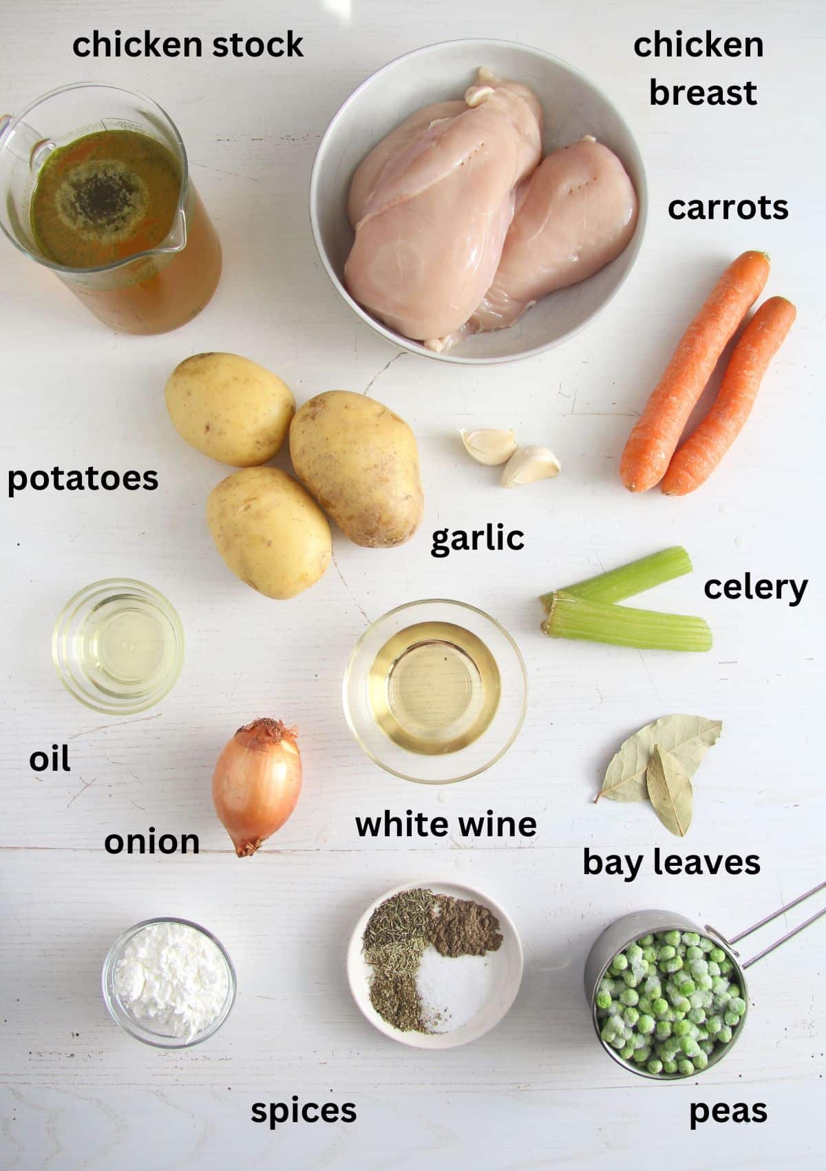 listed ingredients for making chicken stew on a white table.